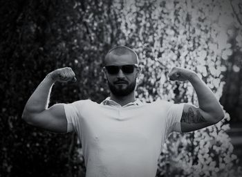 Portrait of young man flexing muscles outdoors
