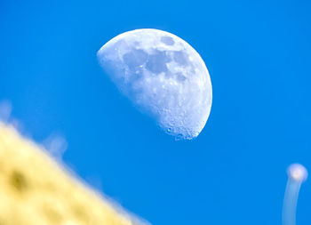 Low angle view of moon against blue sky