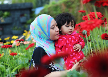 Rear view of mother and daughter on flowering plants