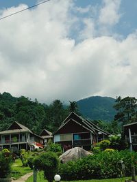 Built structure against trees and mountains against sky