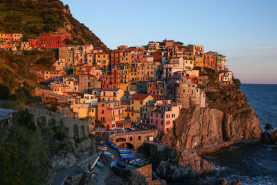 Townscape by sea against sky during sunset