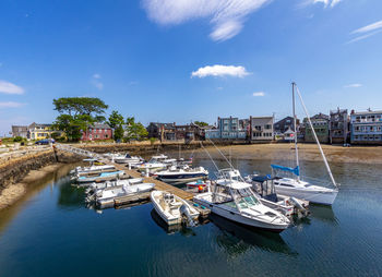 Sailboats moored at harbor