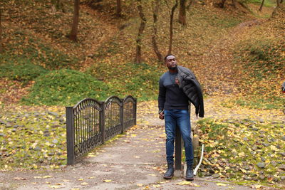 Full length of man standing on street during autumn