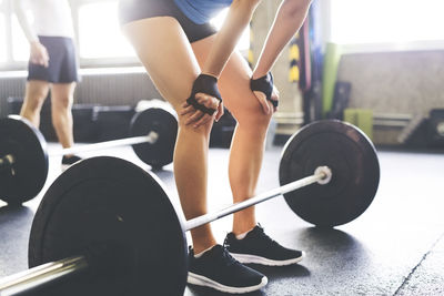 Close-up of woman with barbell in gym