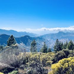 Scenic view of mountains against blue sky