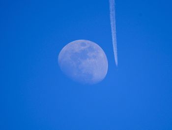 Low angle view of moon against blue sky