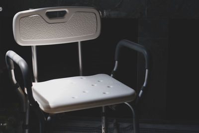 Empty seats on table against wall
