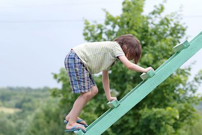 Boy climbing ladder at park