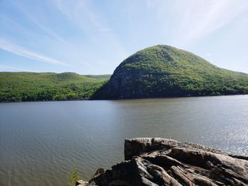 Scenic view of lake by mountain against sky