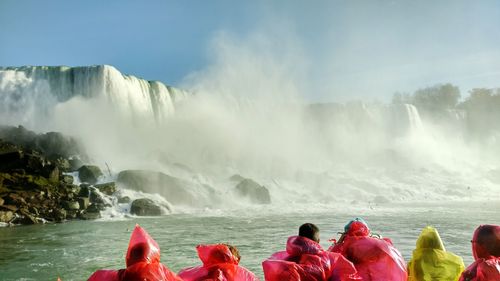 Rear view of people in front of niagara falls