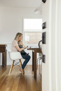 Woman sitting on chair at home
