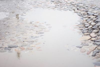 High angle view of wet sand at beach during winter