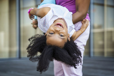 Midsection of mother carrying cheerful girl