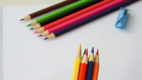 High angle view of colored pencils on white background