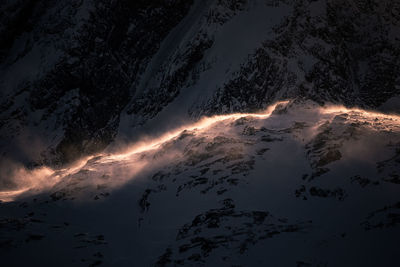 Aerial view of snow covered mountain during sunset