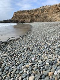 Stones on beach against sky