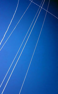 Low angle view of vapor trail against clear blue sky