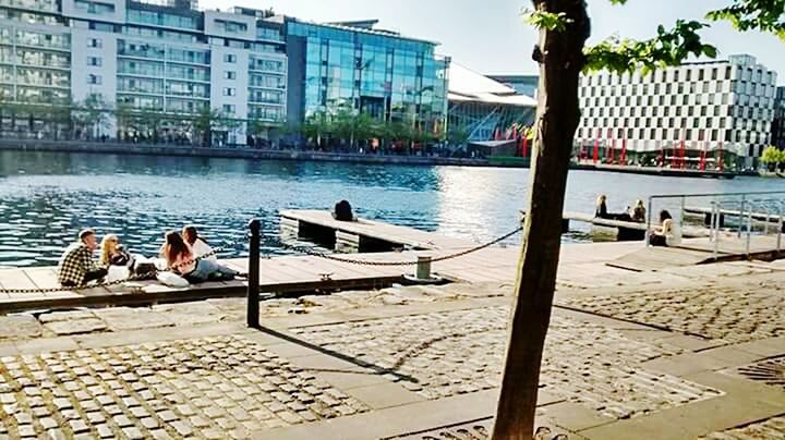 VIEW OF PEOPLE SITTING ON BOAT IN CITY