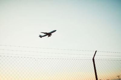 Low angle view of airplane flying against clear sky