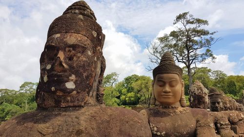 Statue against trees and plants against sky