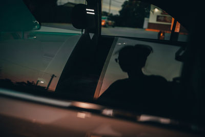 Silhouette man seen through car window