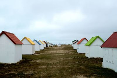 Houses on beach by buildings against sky