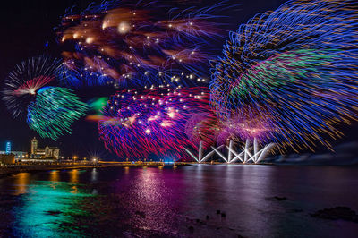 Firework display over river at night