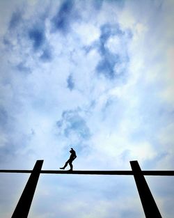 Low angle view of silhouette man walking against sky