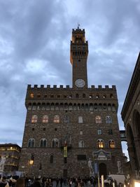 Low angle view of clock tower in city against sky