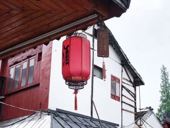 Low angle view of lanterns hanging by building against sky