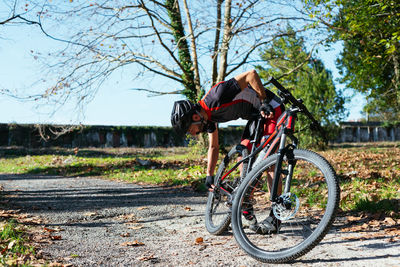 Man standing by bicycle in forest