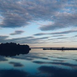 Scenic view of calm lake against cloudy sky