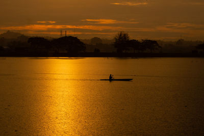 This photo taken on august,12 2021 show a fisherman rowing his boat at sunset in lhokseumawe, aceh.