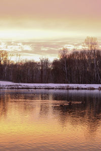 Scenic view of lake against sky at sunset