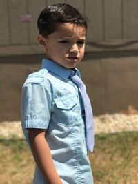 Angry boy standing on field during sunny day