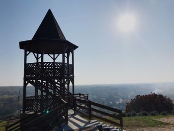 Gazebo on landscape against sky on sunny day