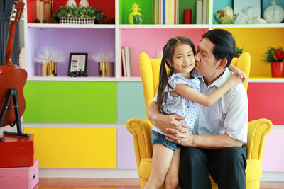 Mother and girl sitting on sofa