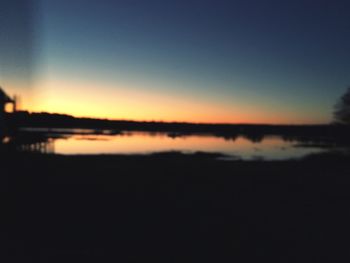 Scenic view of lake against clear sky during sunset
