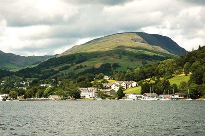 Scenic view of townscape by sea against sky
