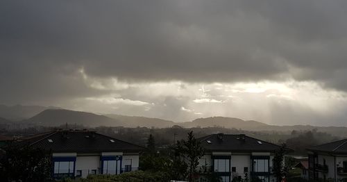 Panoramic view of residential district against storm clouds