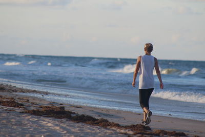 Full length of man standing on beach against sky