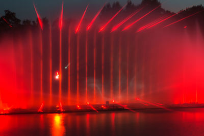 Scenic view of illuminated river against sky at night