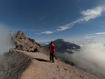 Rear view of man on mountain against sky