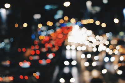 Defocused image of illuminated lights in city at night