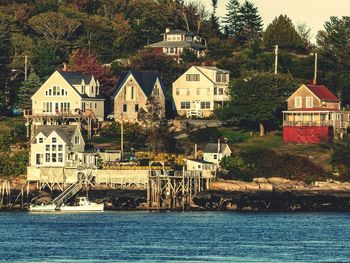 Houses by river against town