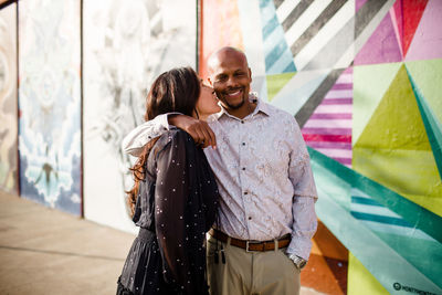 Late forties couple standing in front of mural in san diego