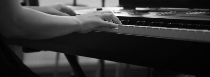 Cropped hands playing piano 