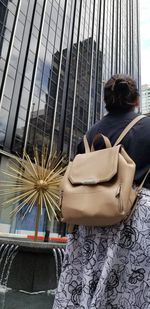 Rear view of woman sitting with umbrella