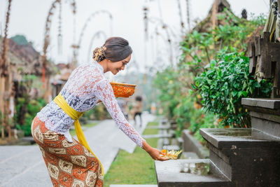 Side view of young woman standing outdoors