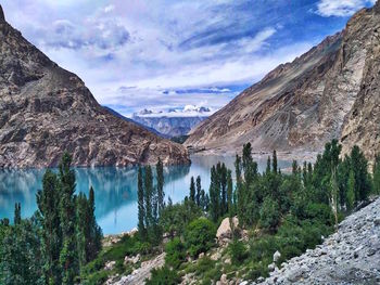 Scenic view of lake and mountains against cloudy sky